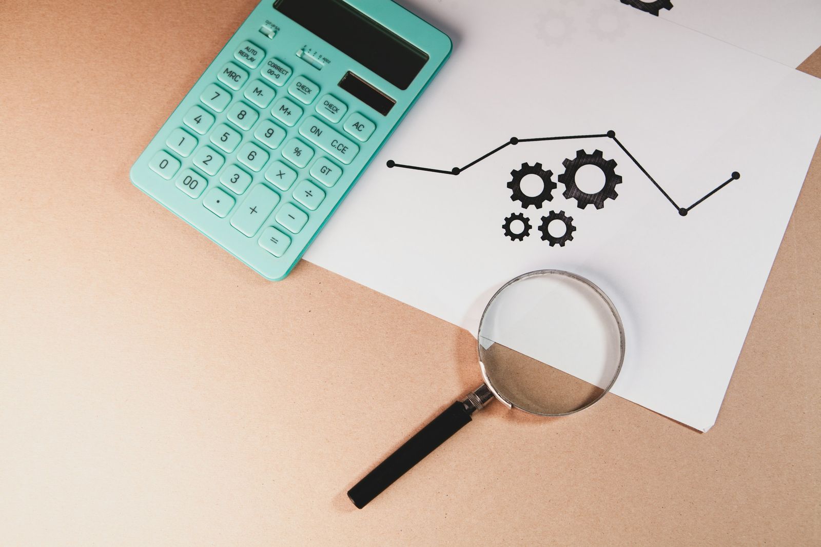 Calculator, magnifying glass and financial charts on a desk