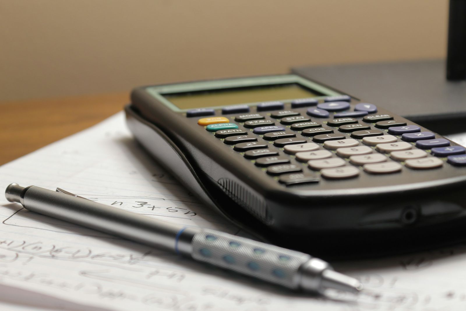 Calculator and pen on a sheet of figures